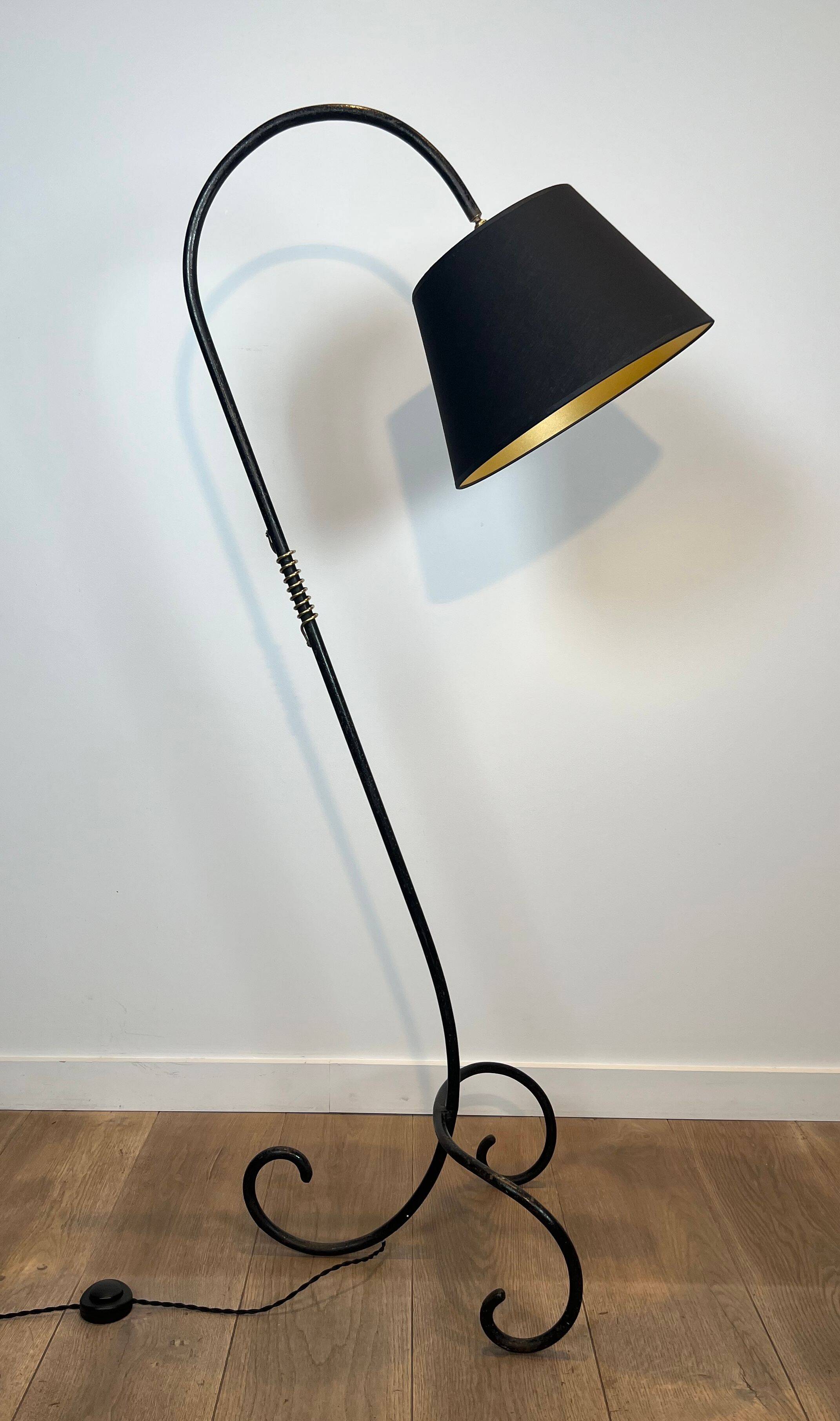 Design floor lamp in black lacquered metal and brass.