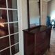Style set: bevelled mirror and curved wooden chest of drawers.