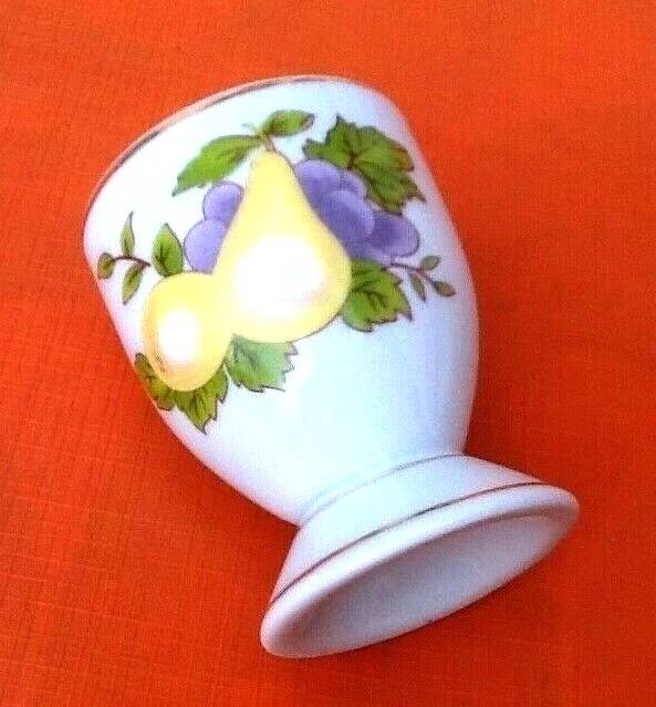 White porcelain egg cup decorated with pears / grapes.