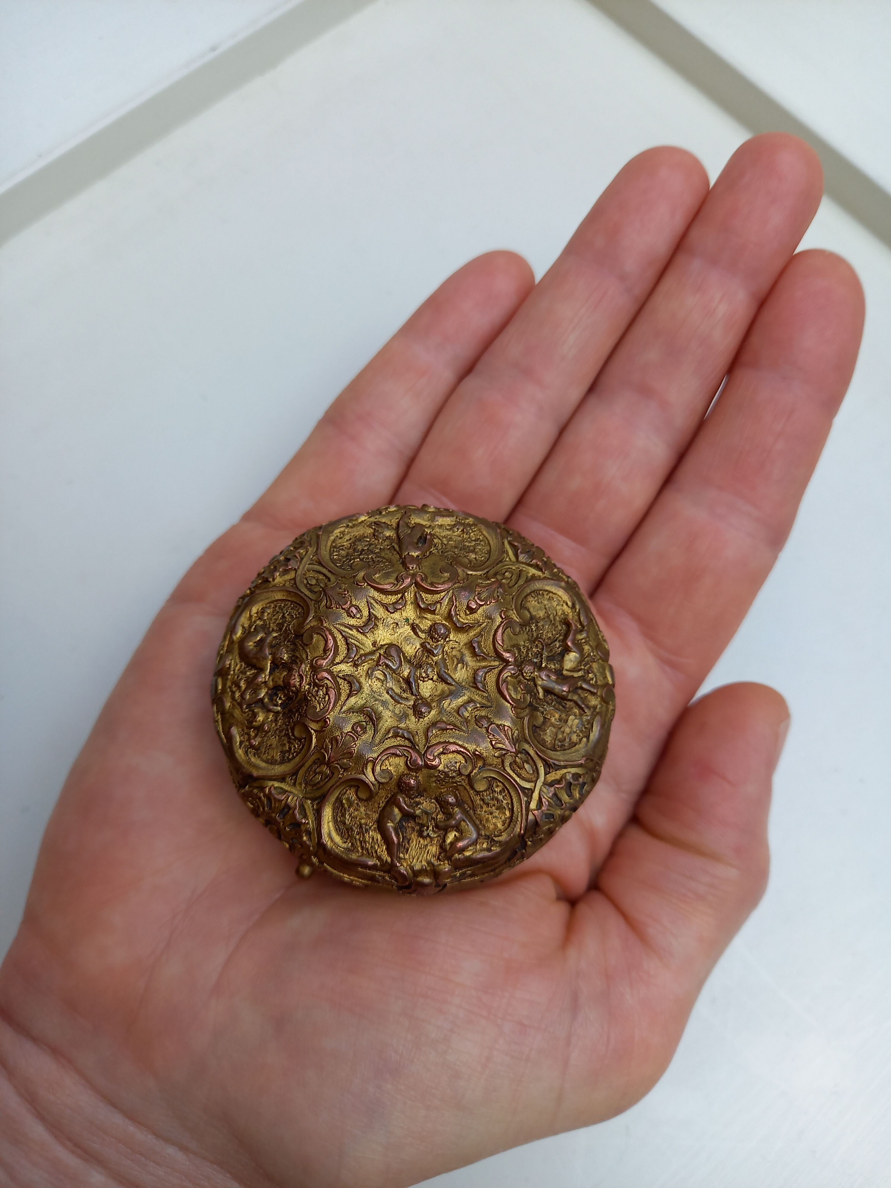 Old brass and copper powder magazine decorated with cherubs