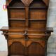 Solid wood bar cabinet with shelves and two stools.