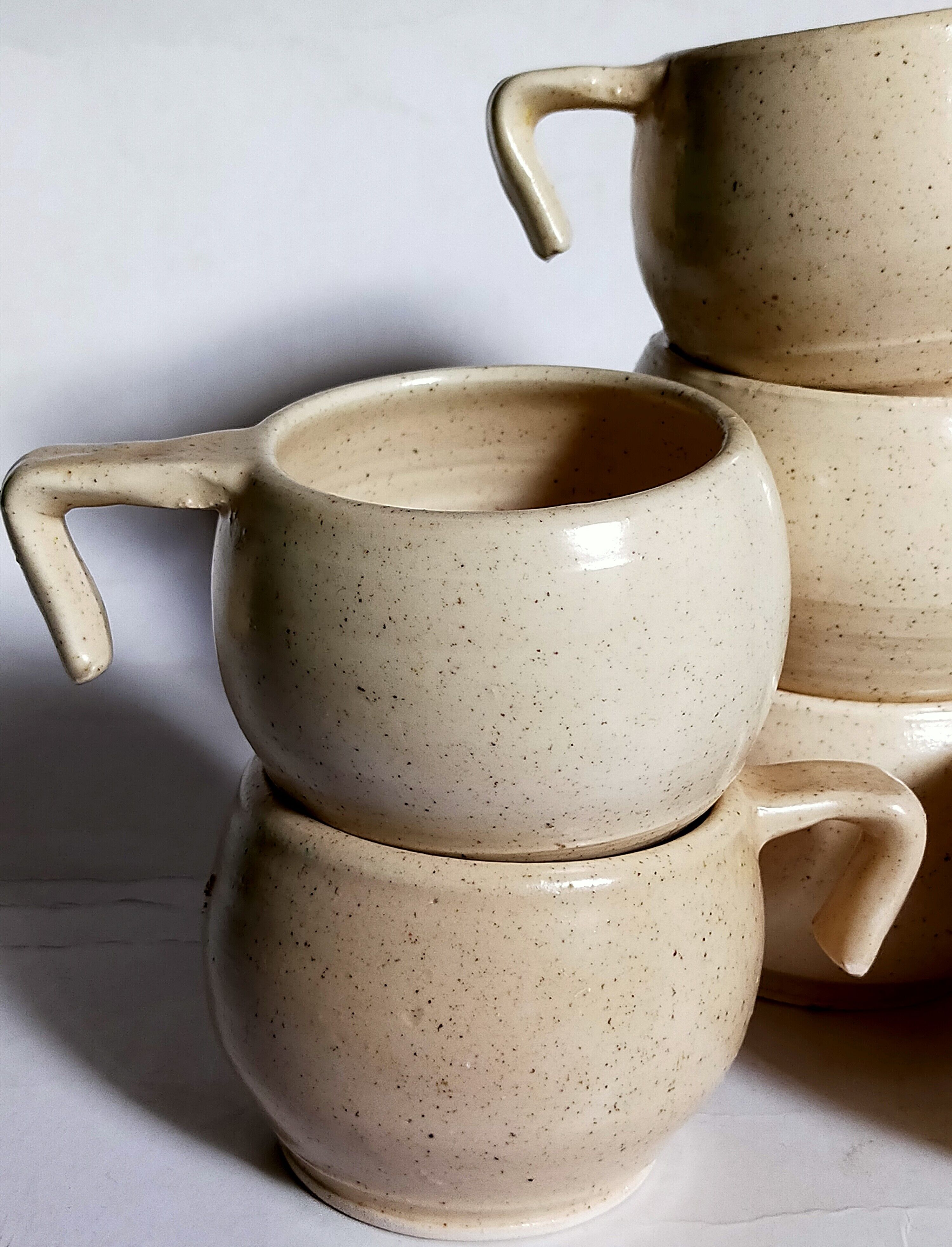 Six vintage potter's ceramic cups with vanilla enamel