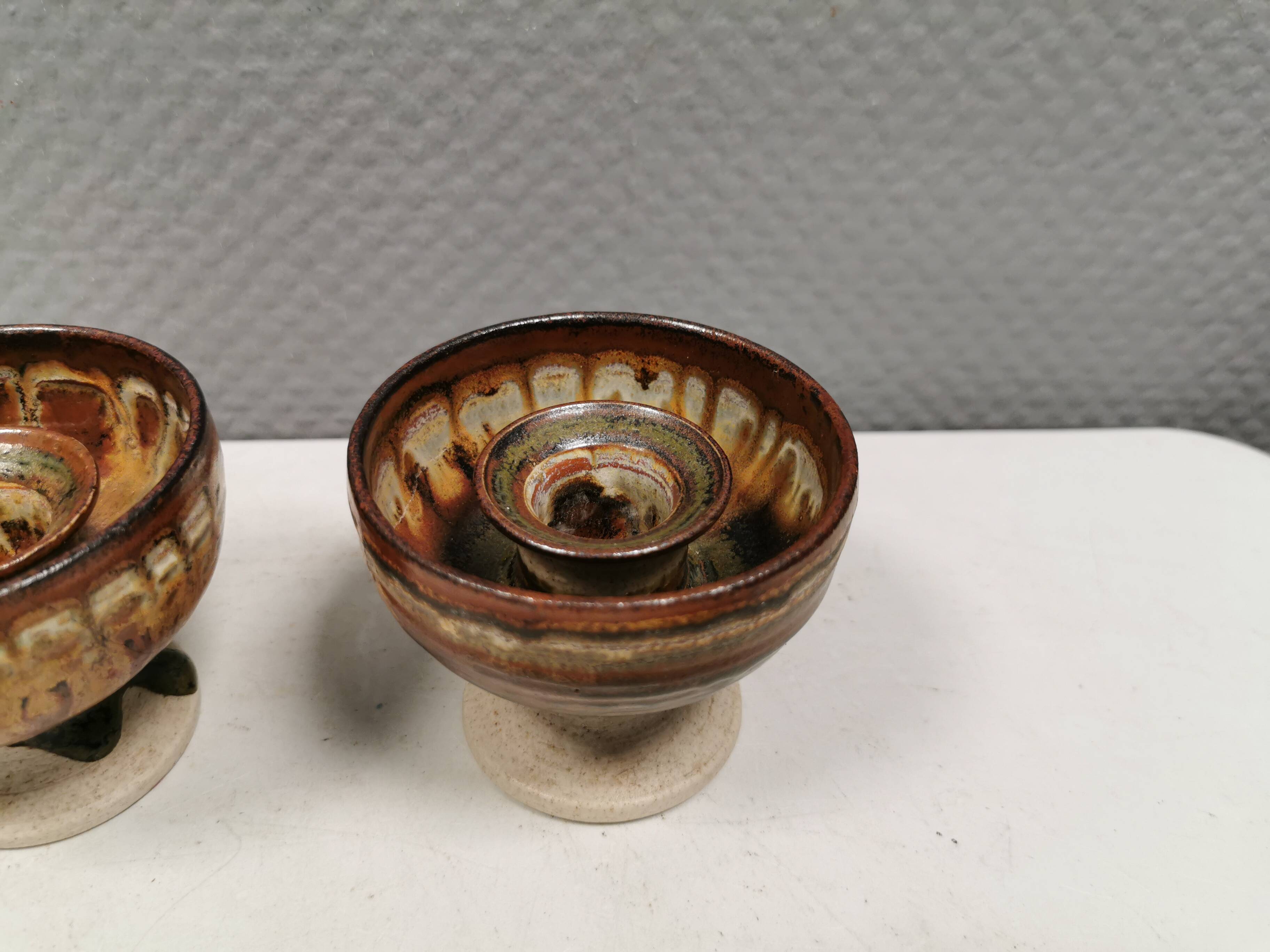 A set of ceramic candle holders in earthy colours.
