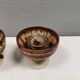 A set of ceramic candle holders in earthy colours.