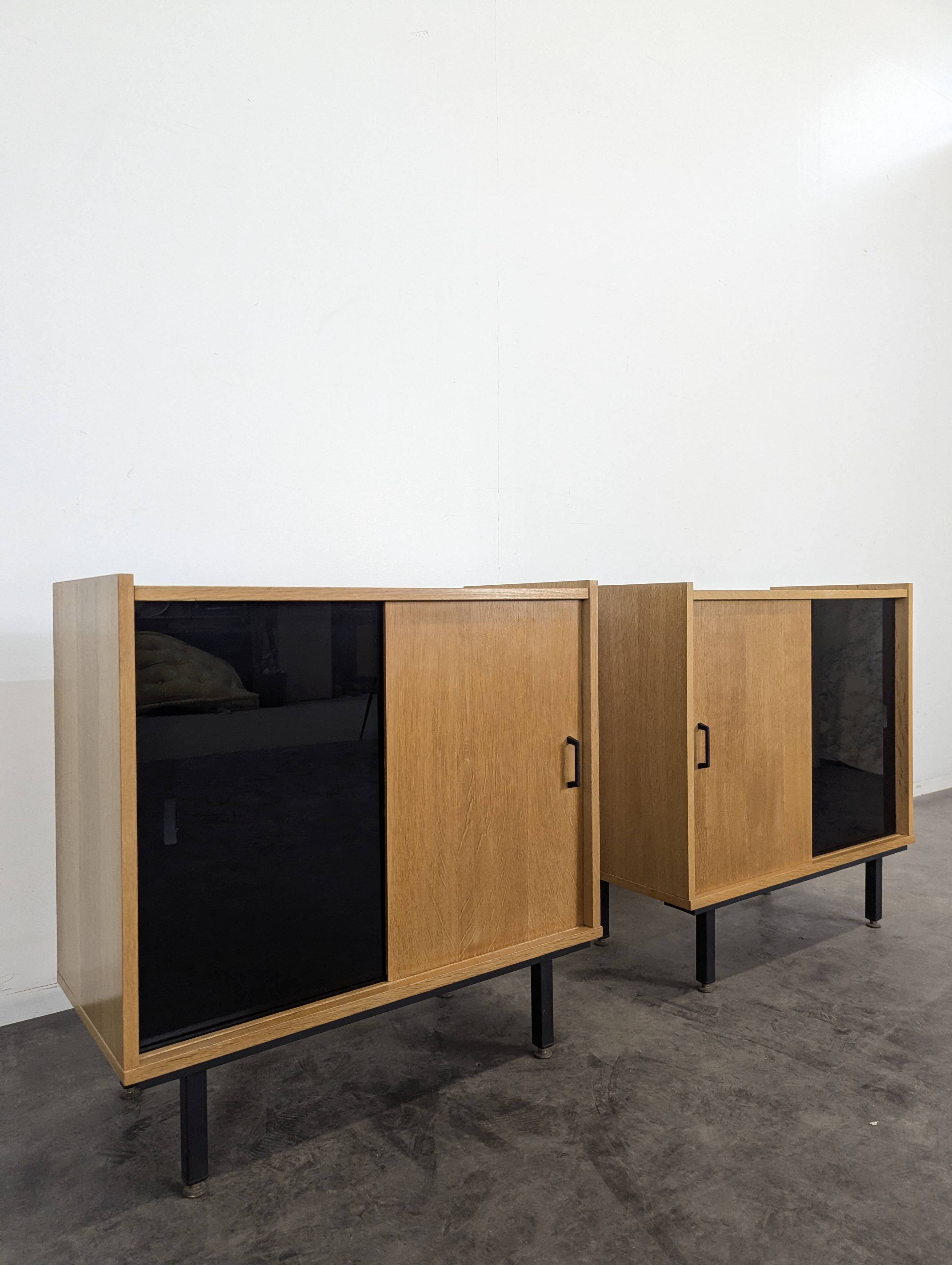 Pair of modernist sideboards with black glass doors in oak veneer.