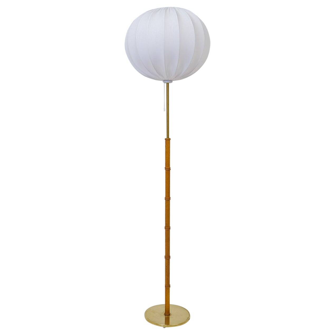 Mid-century floor lamp in brass and oak by Falkenbergs Belysning, Sweden, 1960s.