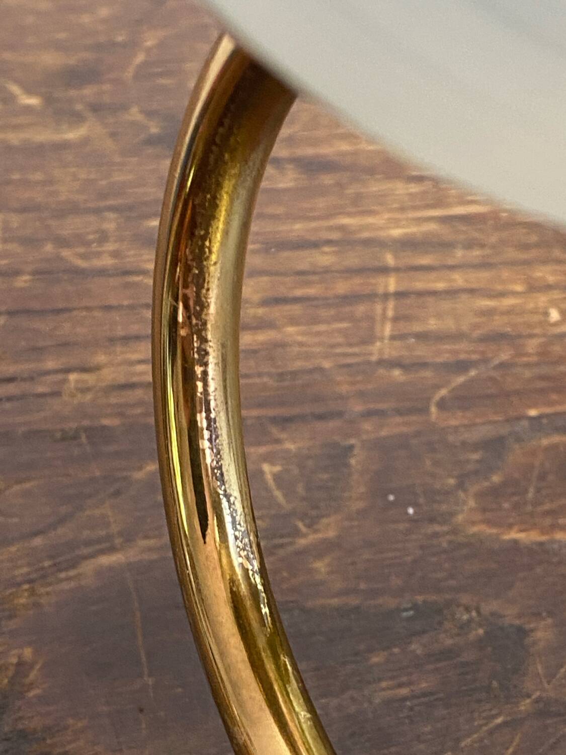Gold metal wall light with ribbed glass.