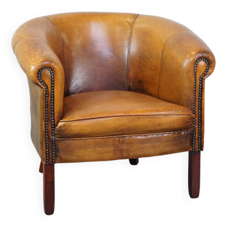Subtle sheepskin club chair finished with decorative studs