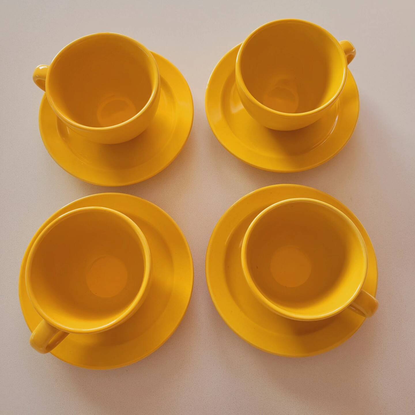 4 yellow cups and saucers