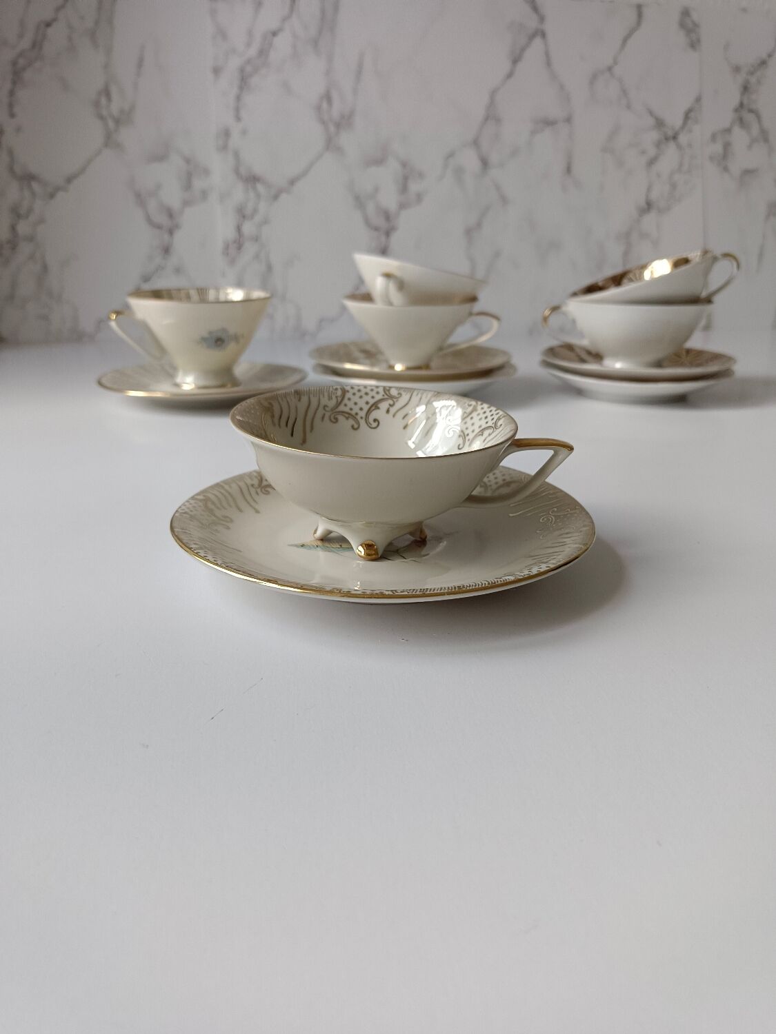 Set of mismatched fine porcelain cups signed with saucer