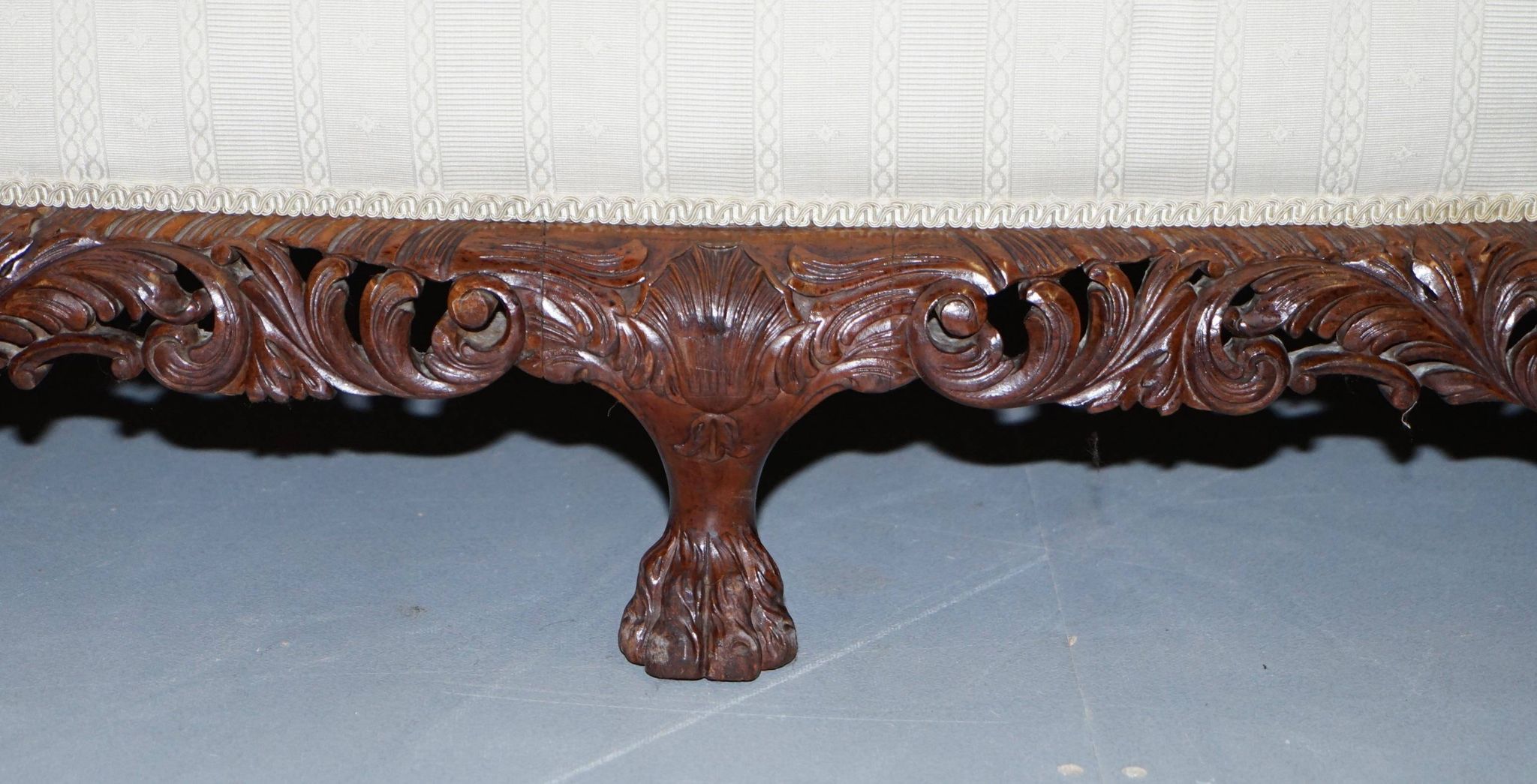 Three-seater canapé carved from solid walnut with claw feet.