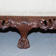Three-seater canapé carved from solid walnut with claw feet.