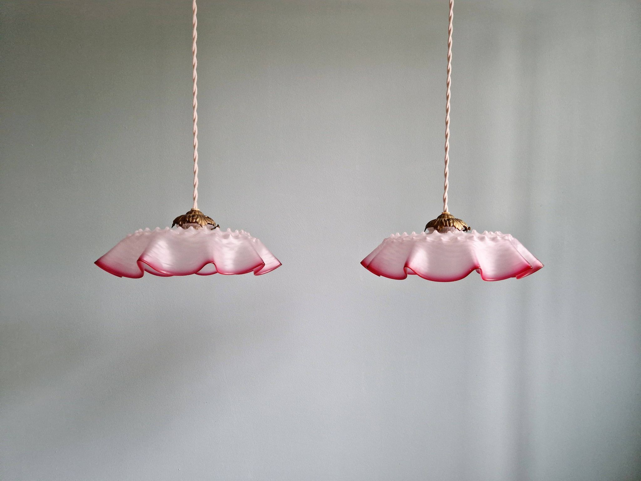 Pair of clear and pink satin glass scalloped pendant lights, 1920s-30s