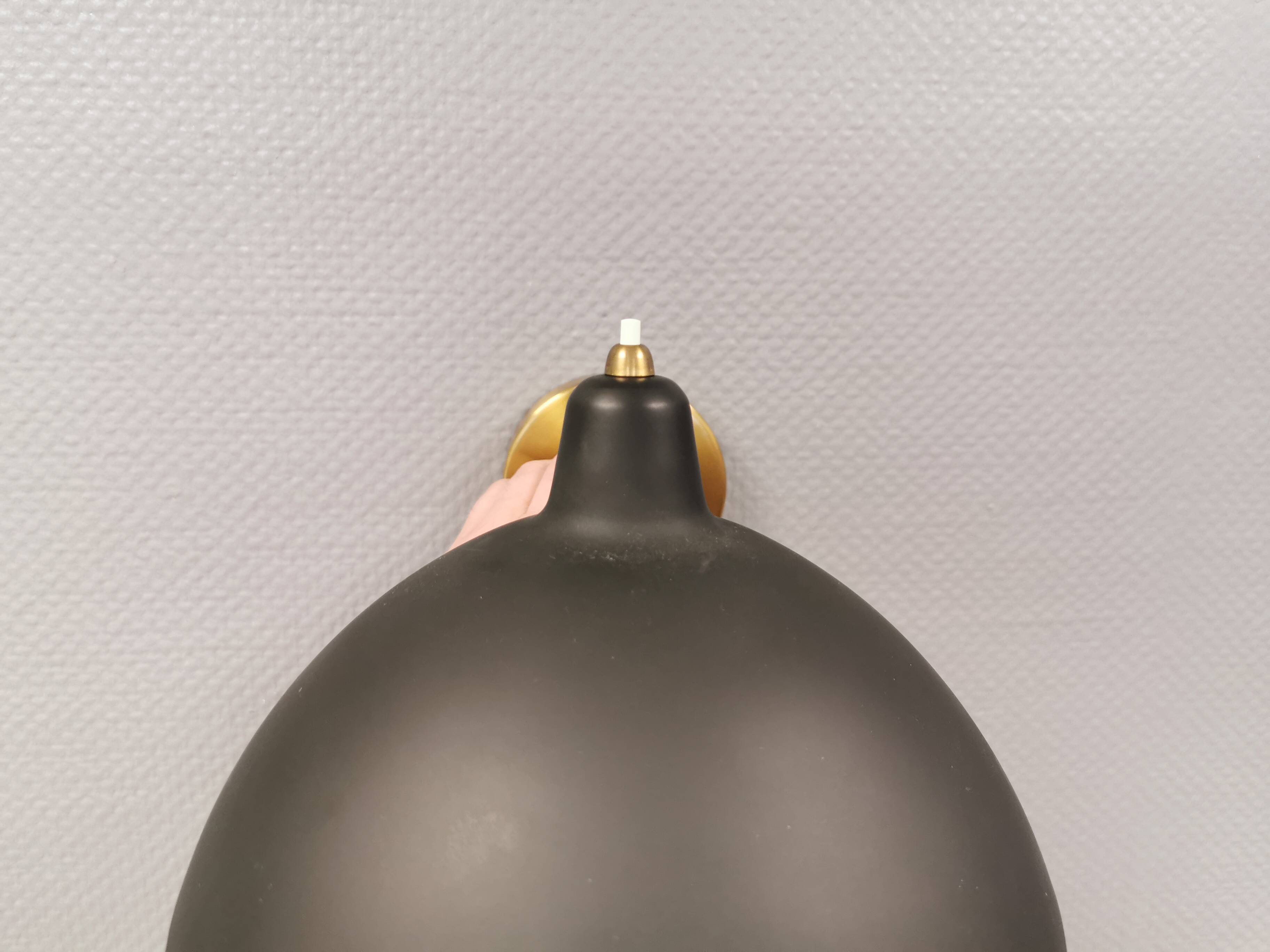 A wall lamp in black and brass-coloured finishes. Danish, early 2000s.