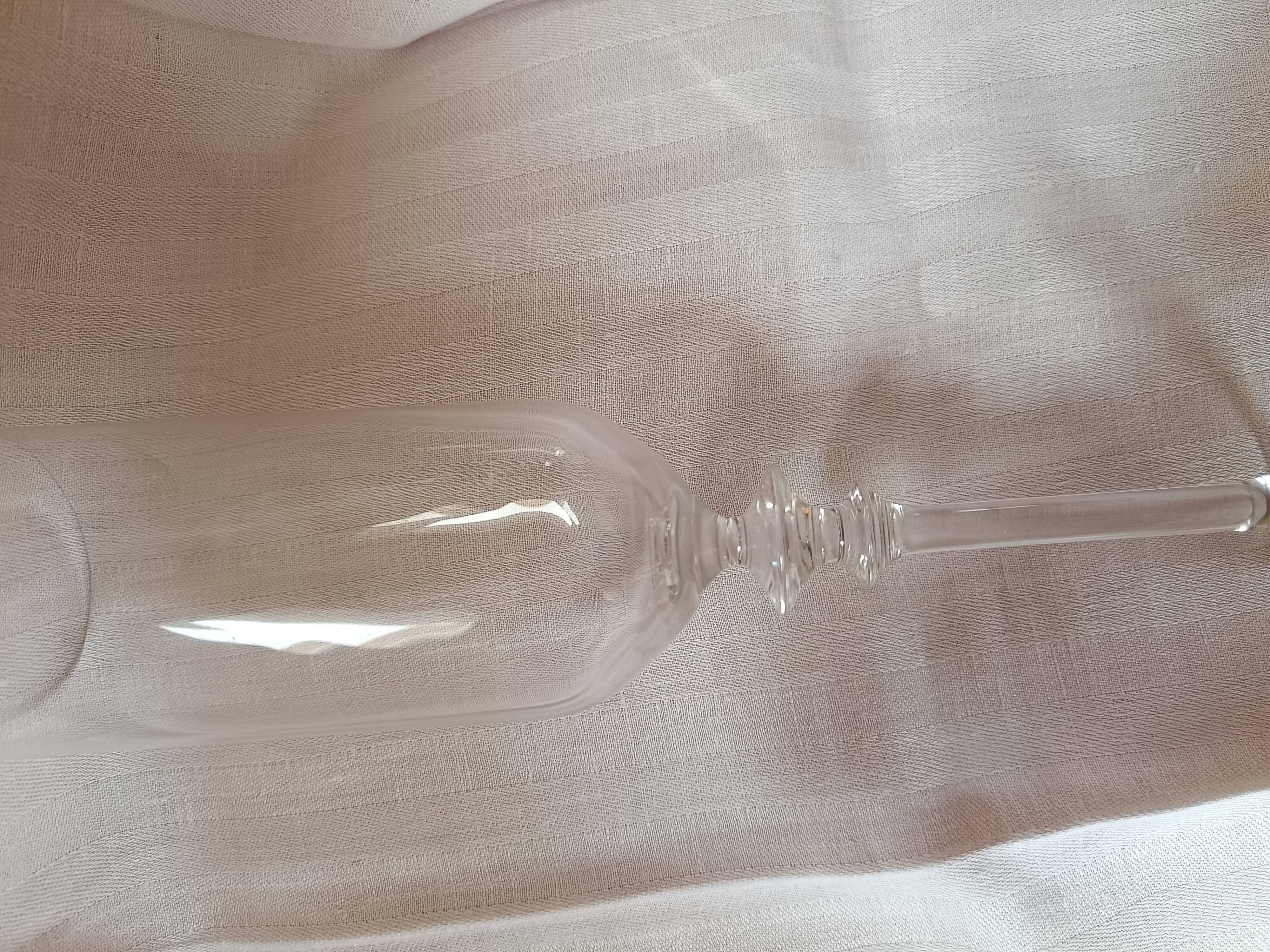 4 crystal champagne flutes with feet decorated with two knots.