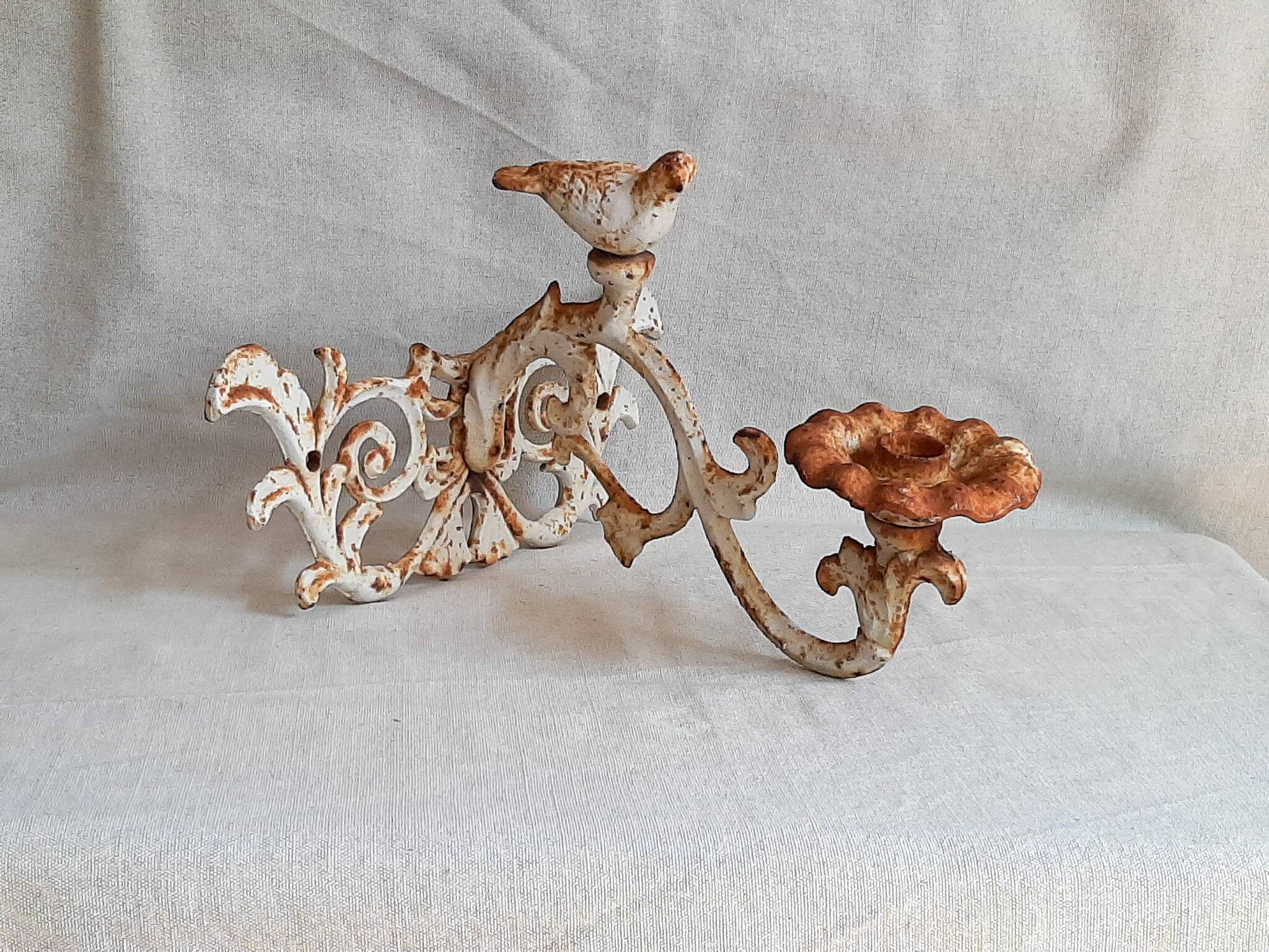 Wall lamp in antique cast iron with bird and scroll decorations.