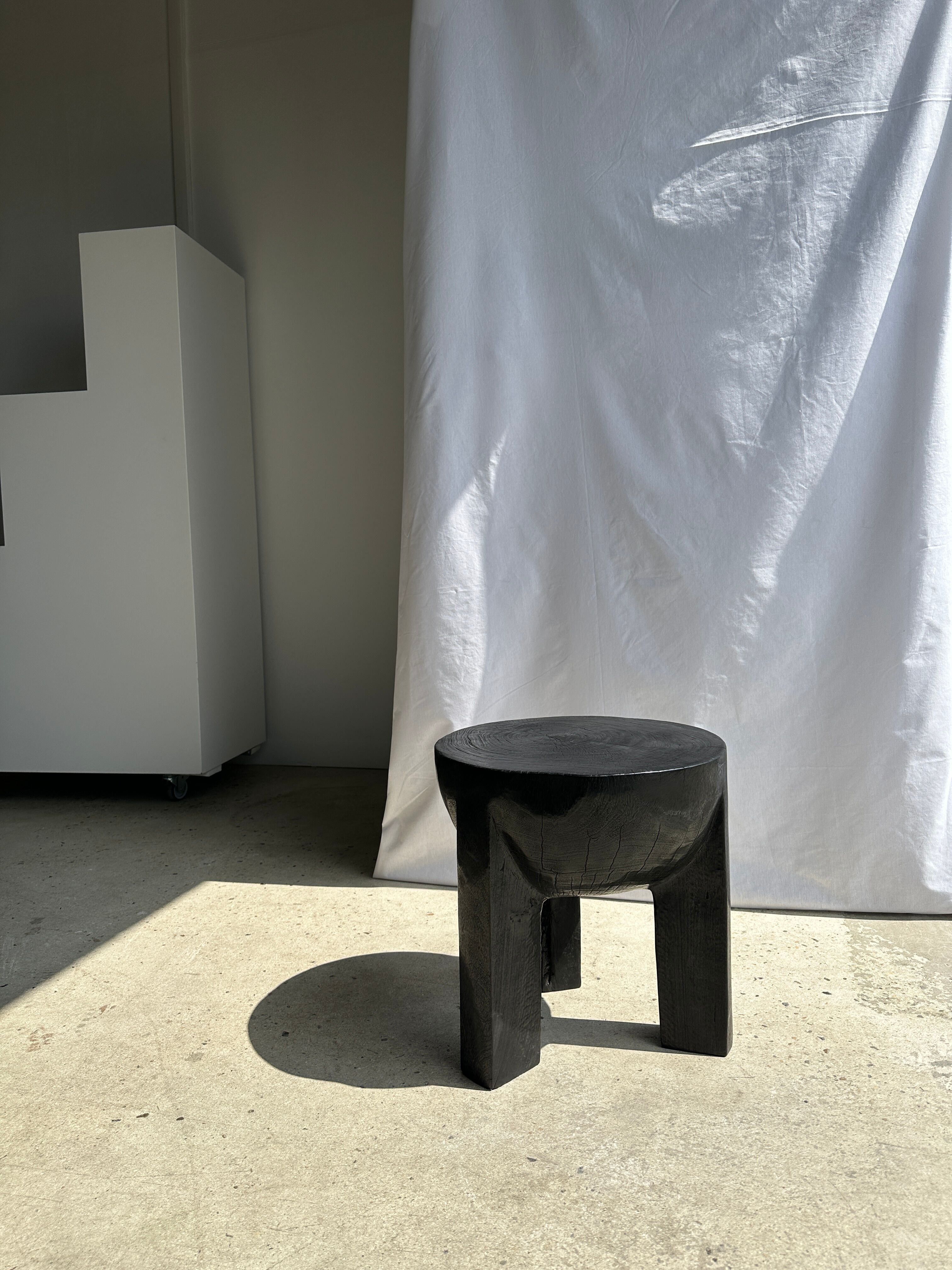 Black mango wood tripod side table with a semi-spherical top, height: 45 cm, diameter: 44 cm.