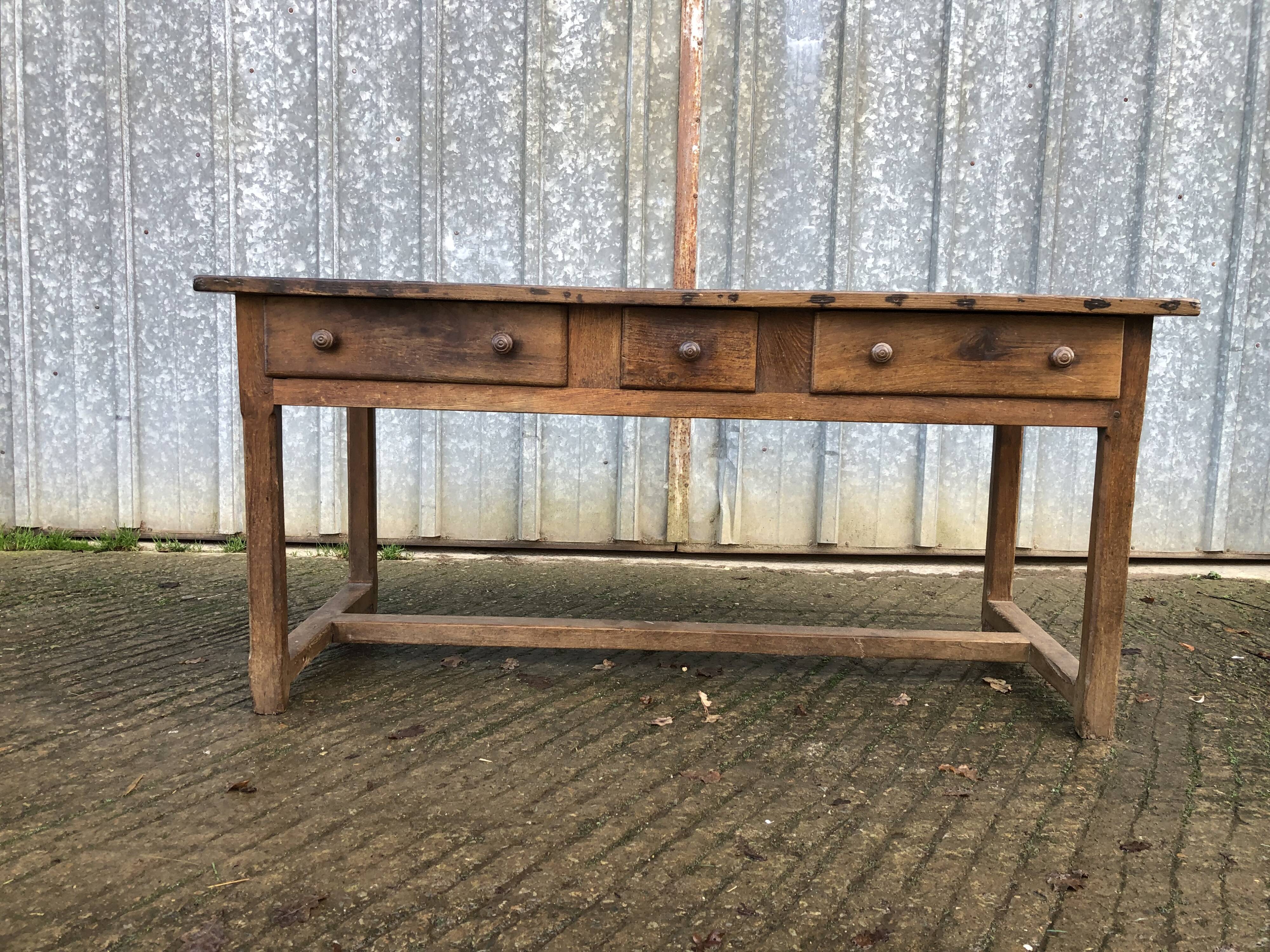 Old chestnut table with 3 front drawers and a cat bar.