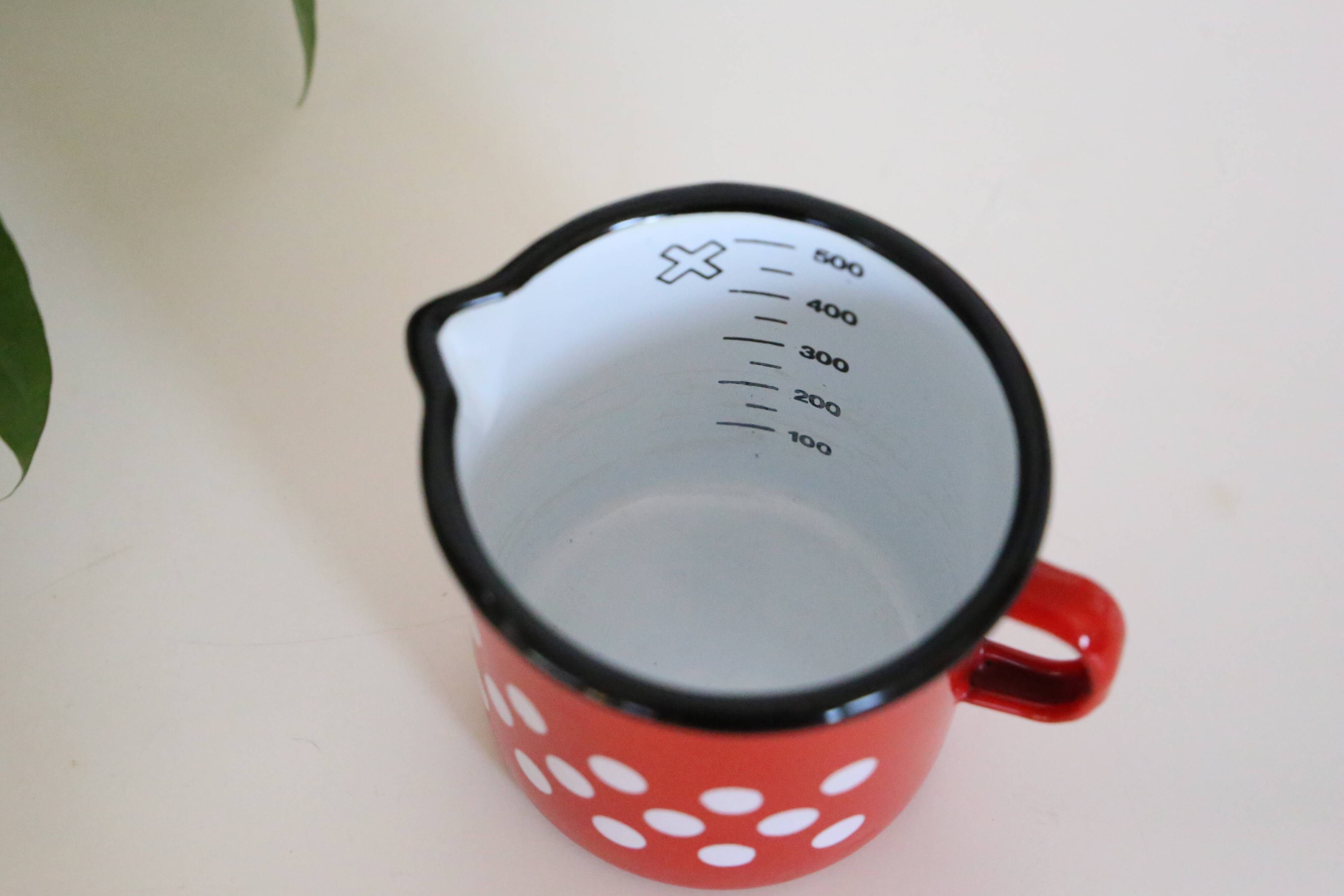 Red enamelled metal milk pot