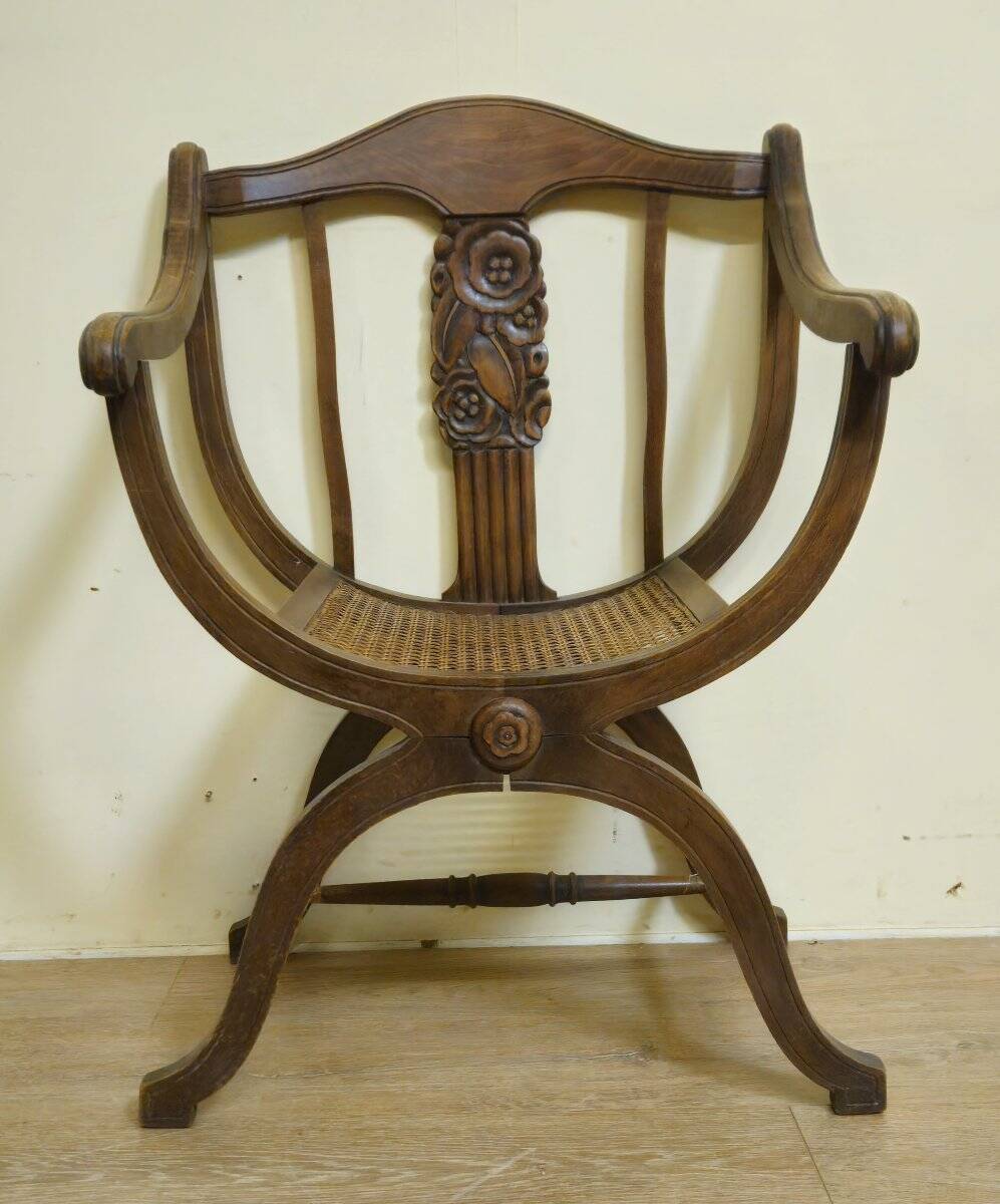 Fauteuil curule de style Art Nouveau en noyer sculpté et assise cannée