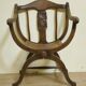 Fauteuil curule de style Art Nouveau en noyer sculpté et assise cannée