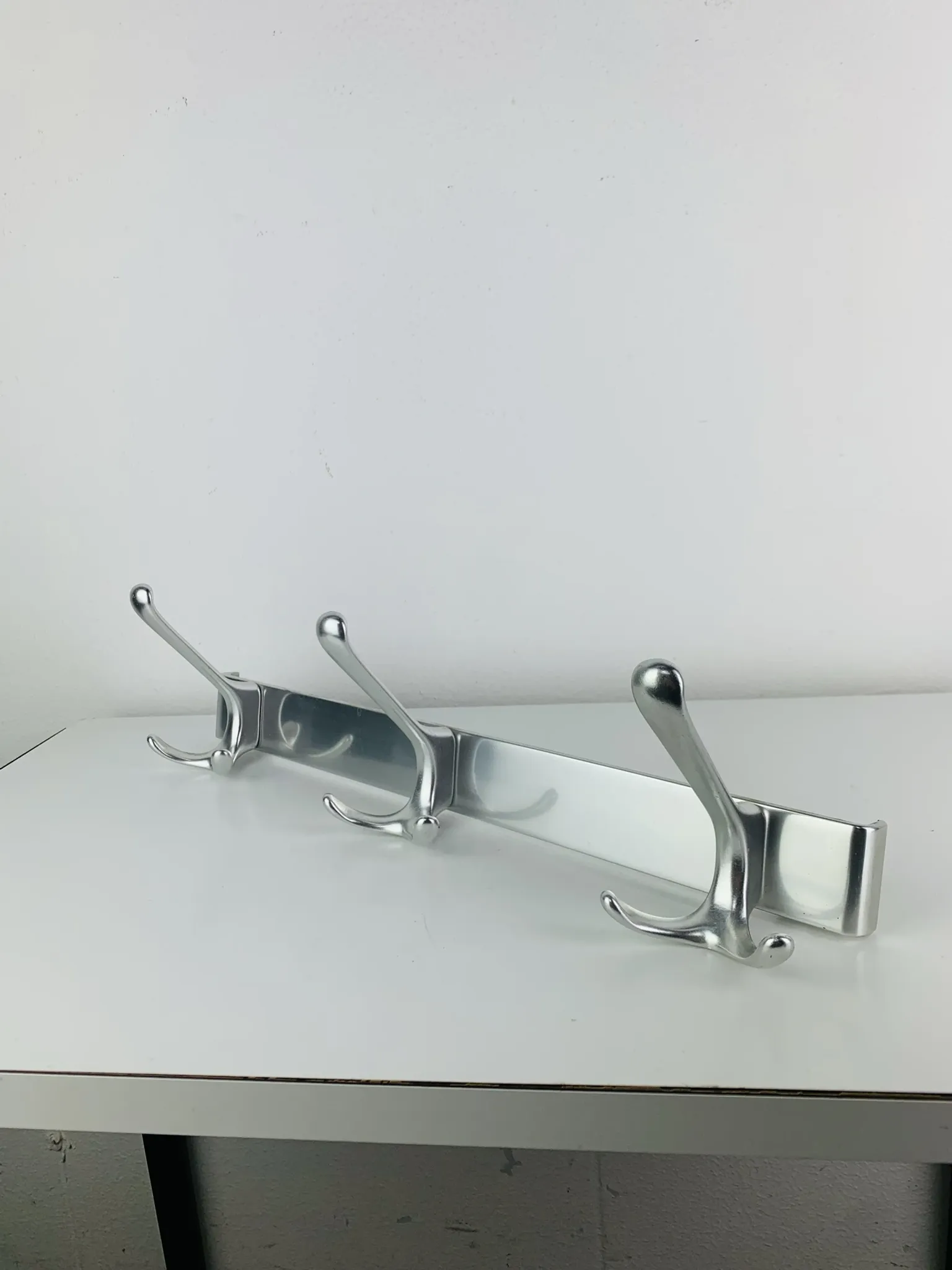 Wall-mounted coat rack, strip of 3 aluminium hooks from the 1960s.