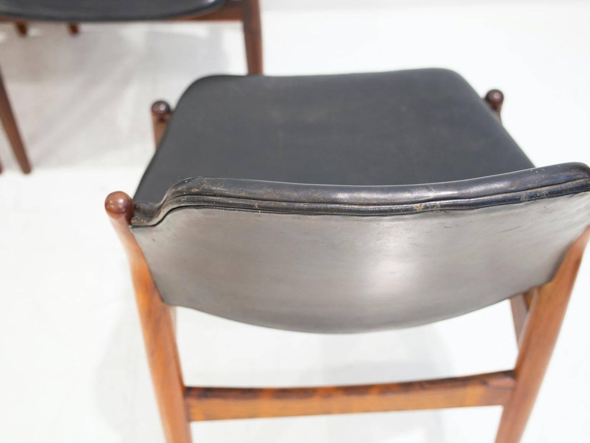 Set of four Arne Vodder chairs in hardwood and black leather.