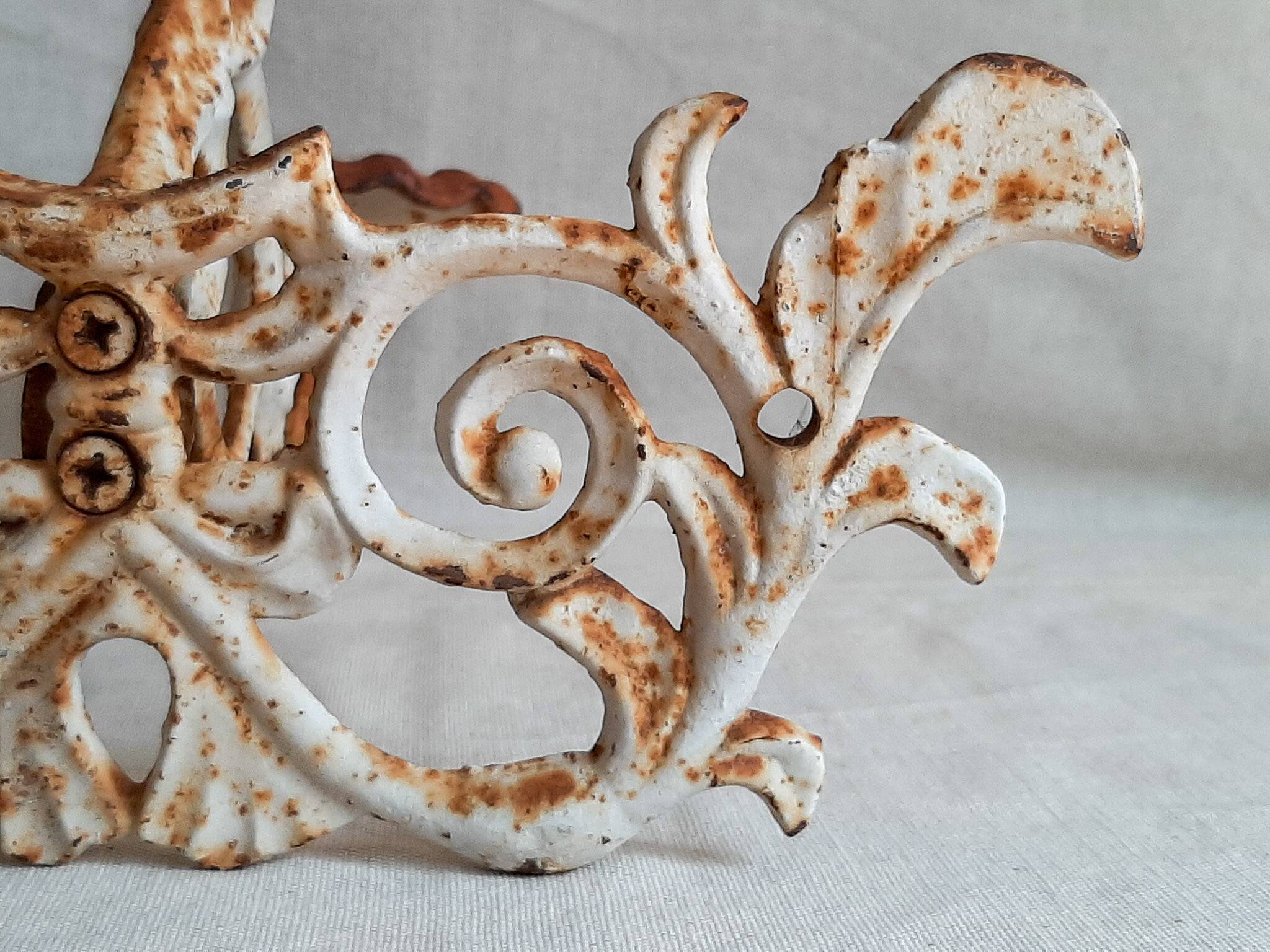 Wall lamp in antique cast iron with bird and scroll decorations.