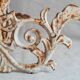 Wall lamp in antique cast iron with bird and scroll decorations.