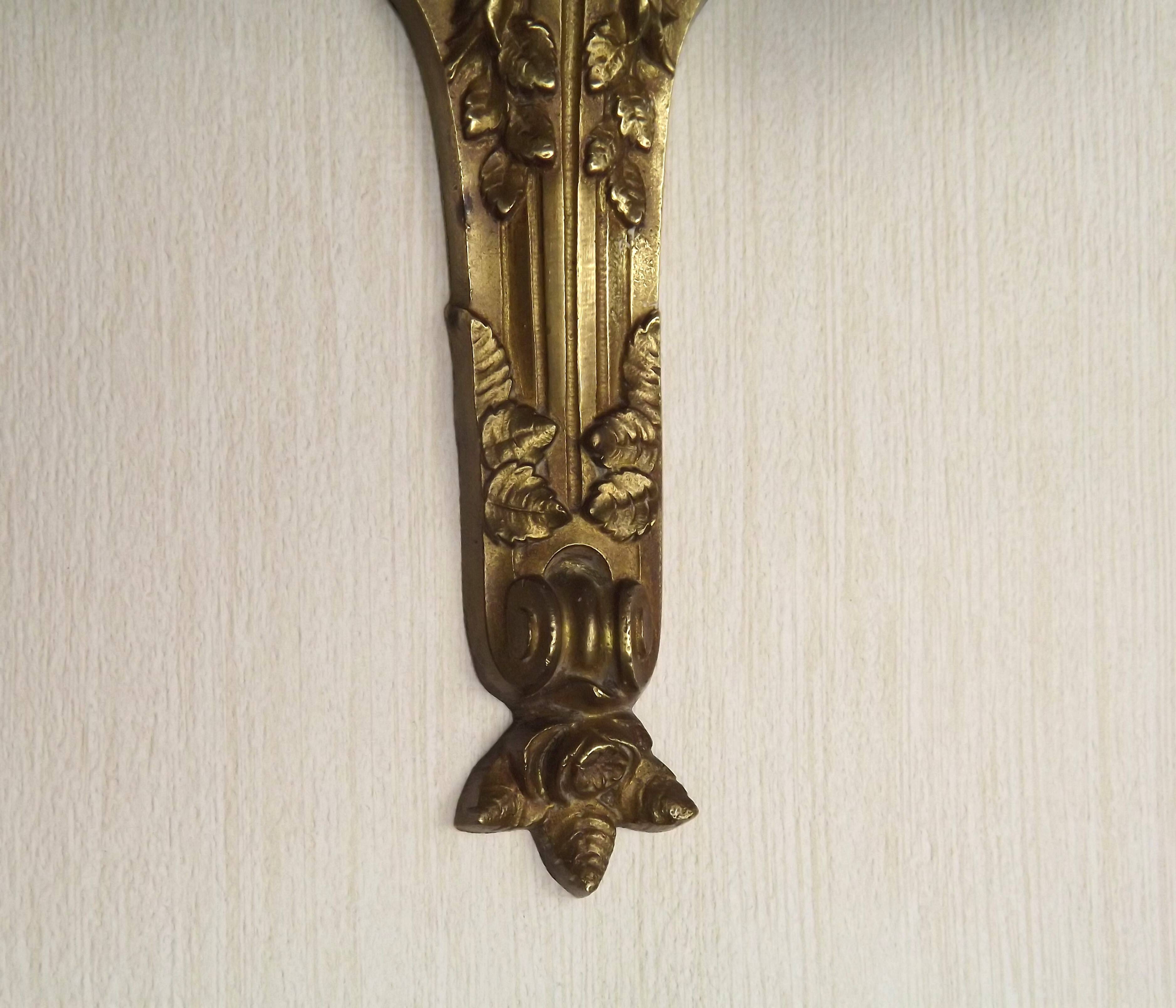 Double wall light in bronze in French Rococo style with white glass shades featuring patterns.