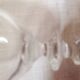 4 crystal champagne flutes with feet decorated with two knots.