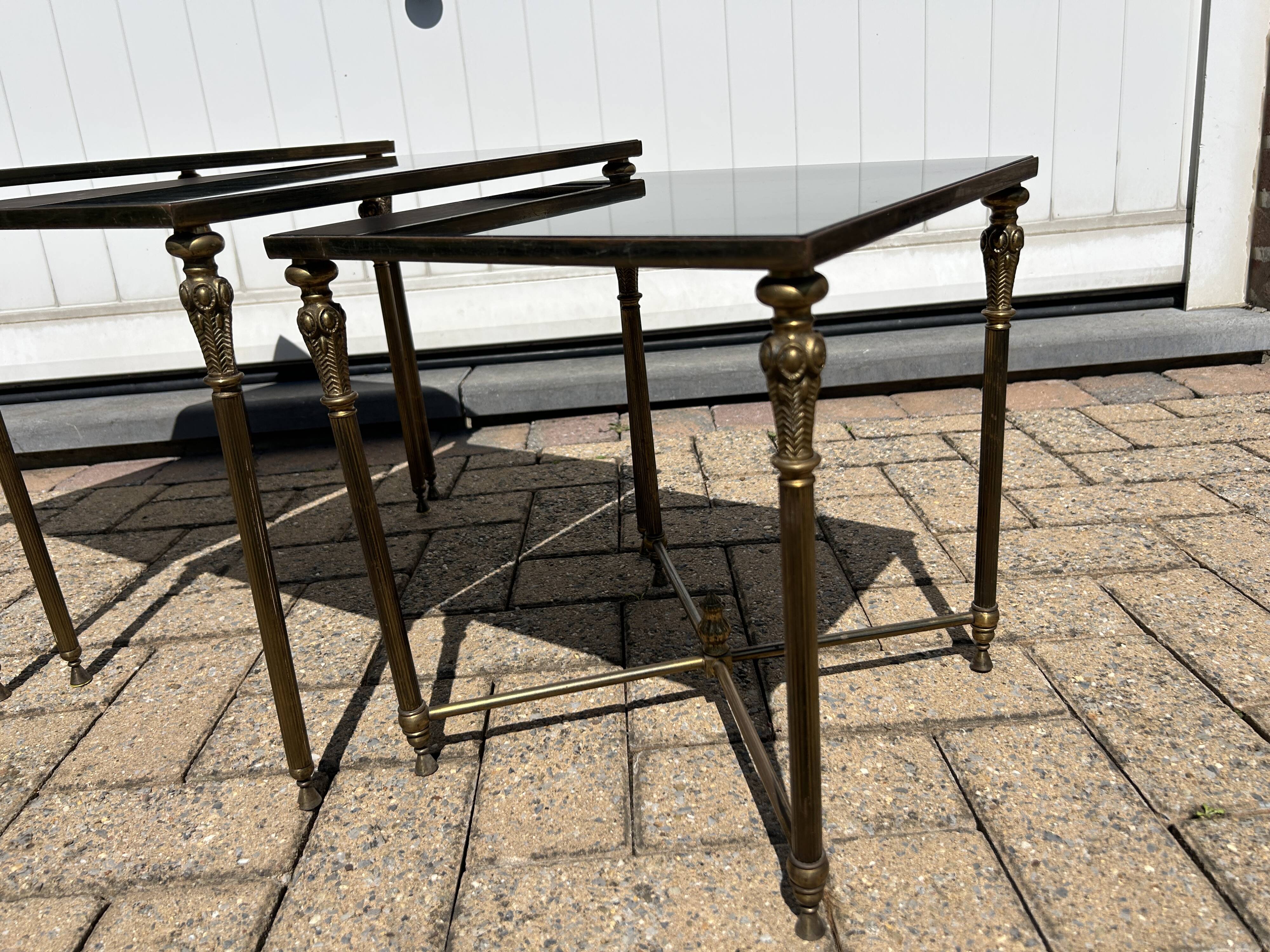 Nested tables in gilded brass in the style of Maison Charles.