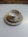 Solitaire tea cup, saucer, and dessert plate in white and gold.