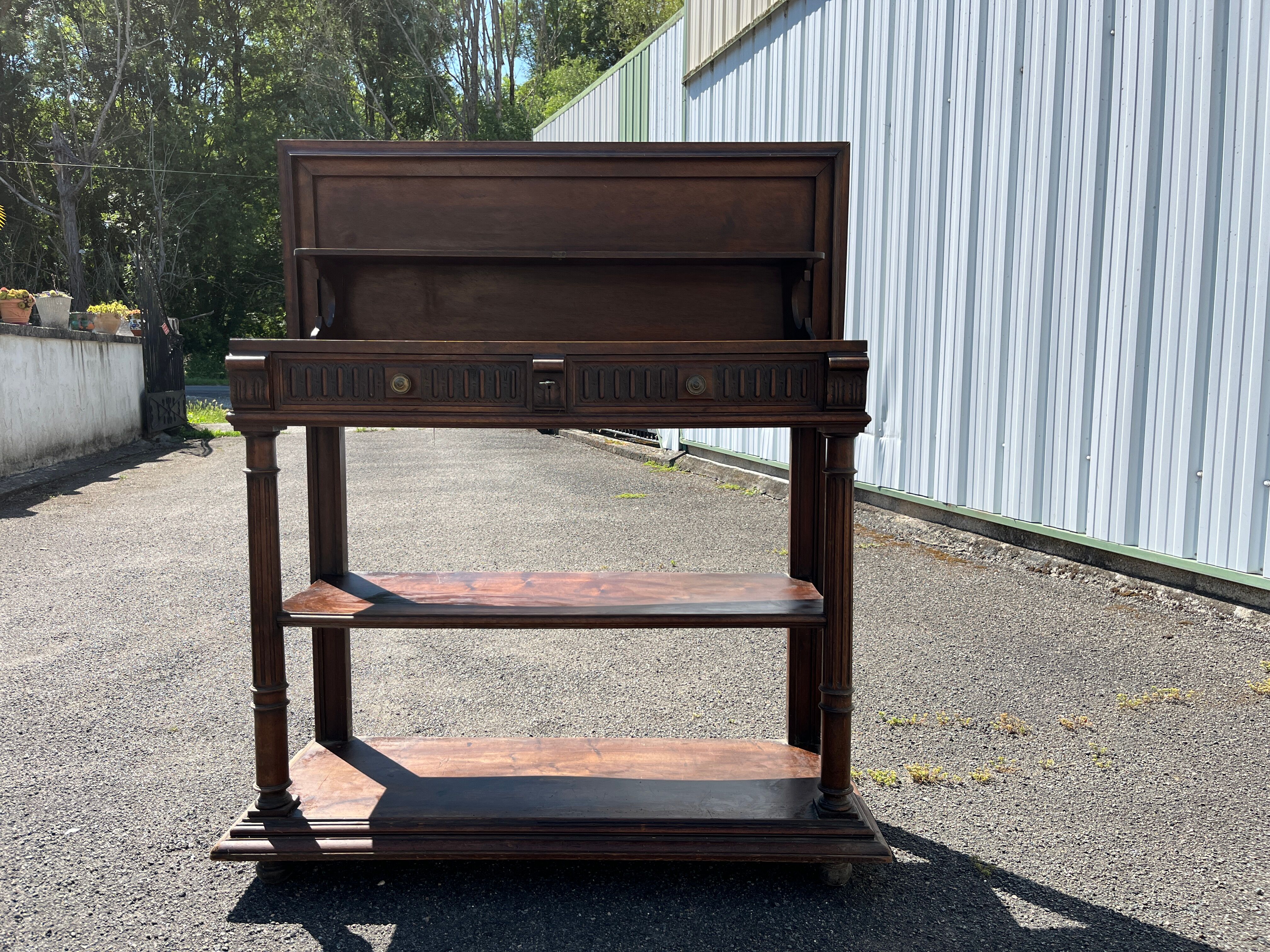 Carved wooden console table with three shelves and drop-leaf flap