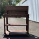 Carved wooden console table with three shelves and drop-leaf flap