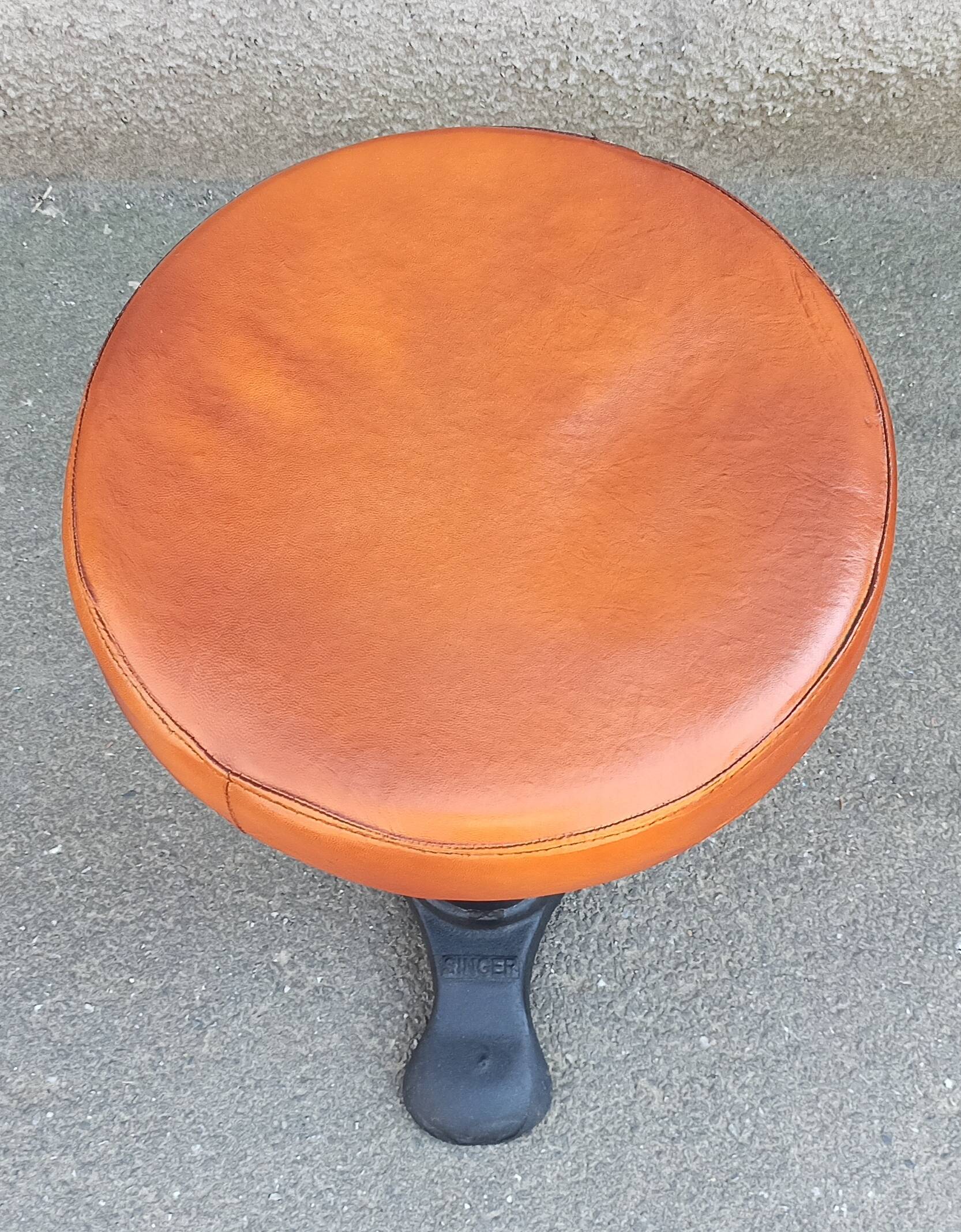 Height-adjustable leather stool with cast iron base