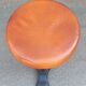 Height-adjustable leather stool with cast iron base