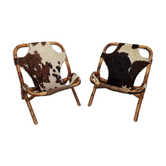 Paire de fauteuils en bambou et rotin assises en peau de vache