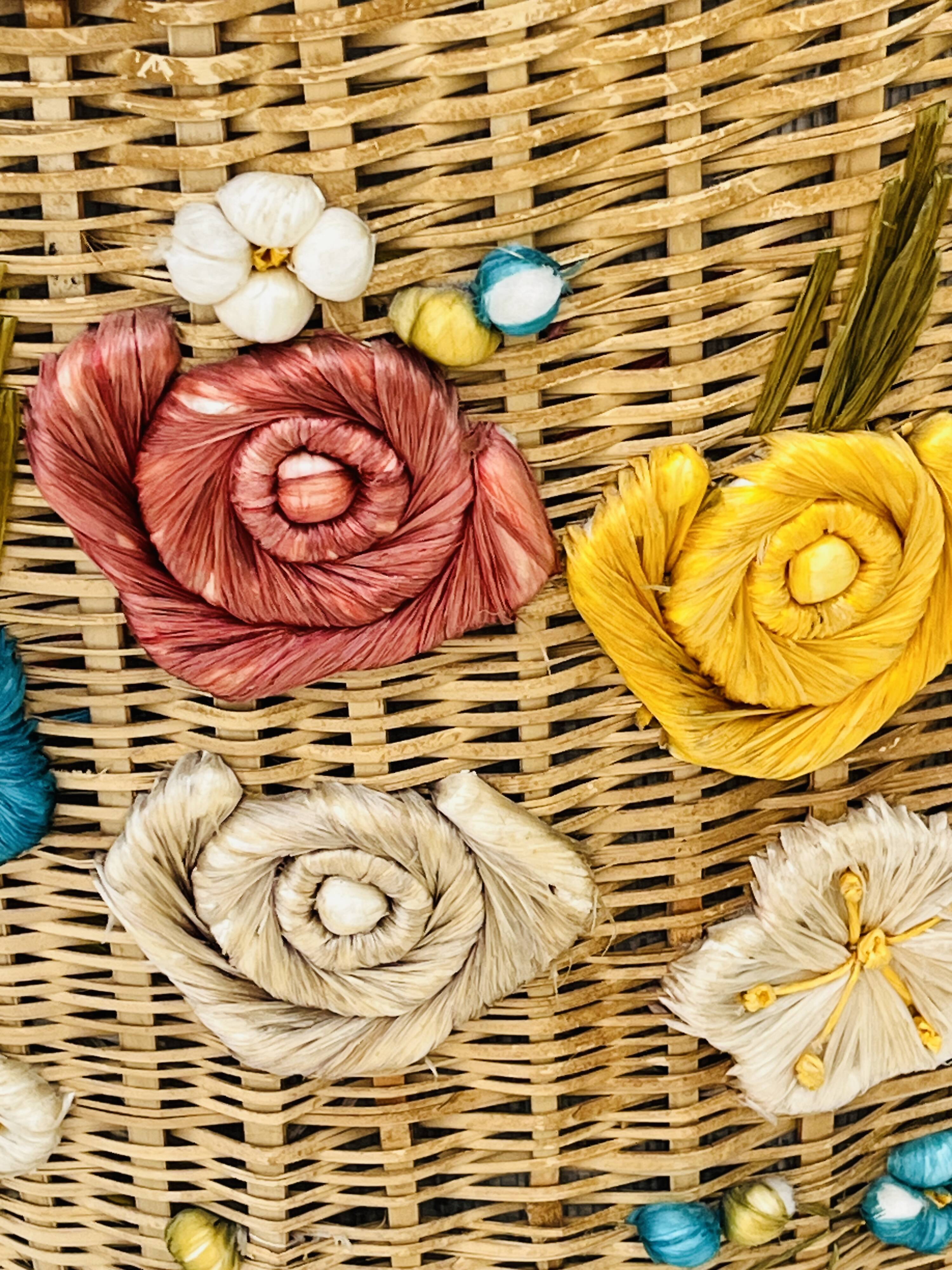 Vintage wicker mannequin with colourful floral decoration.