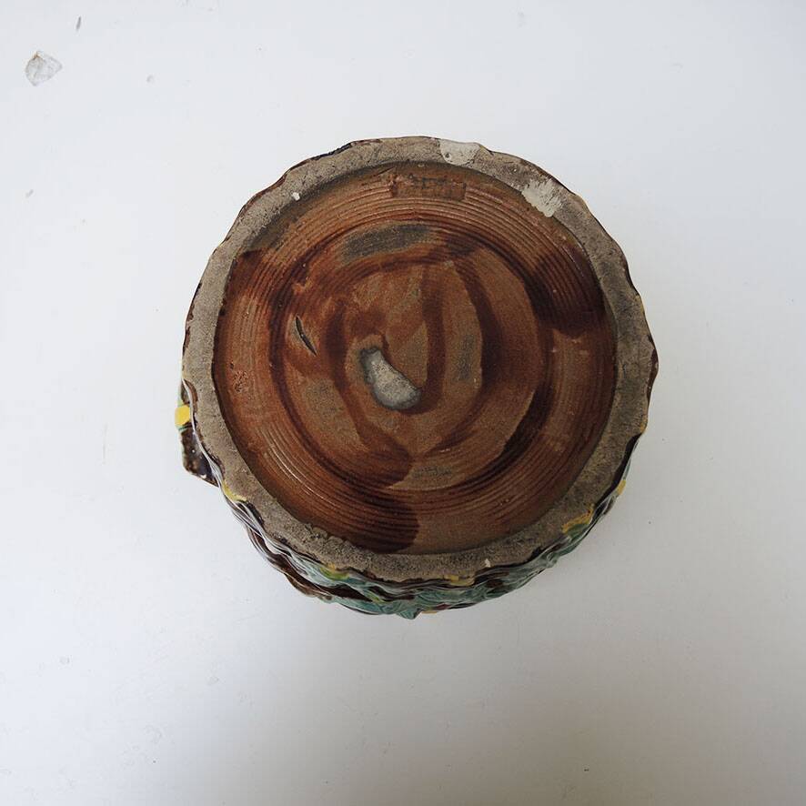 Old earthenware pot with ivy decoration.