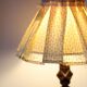Table lamp with a carved wooden base and pleated lampshade
