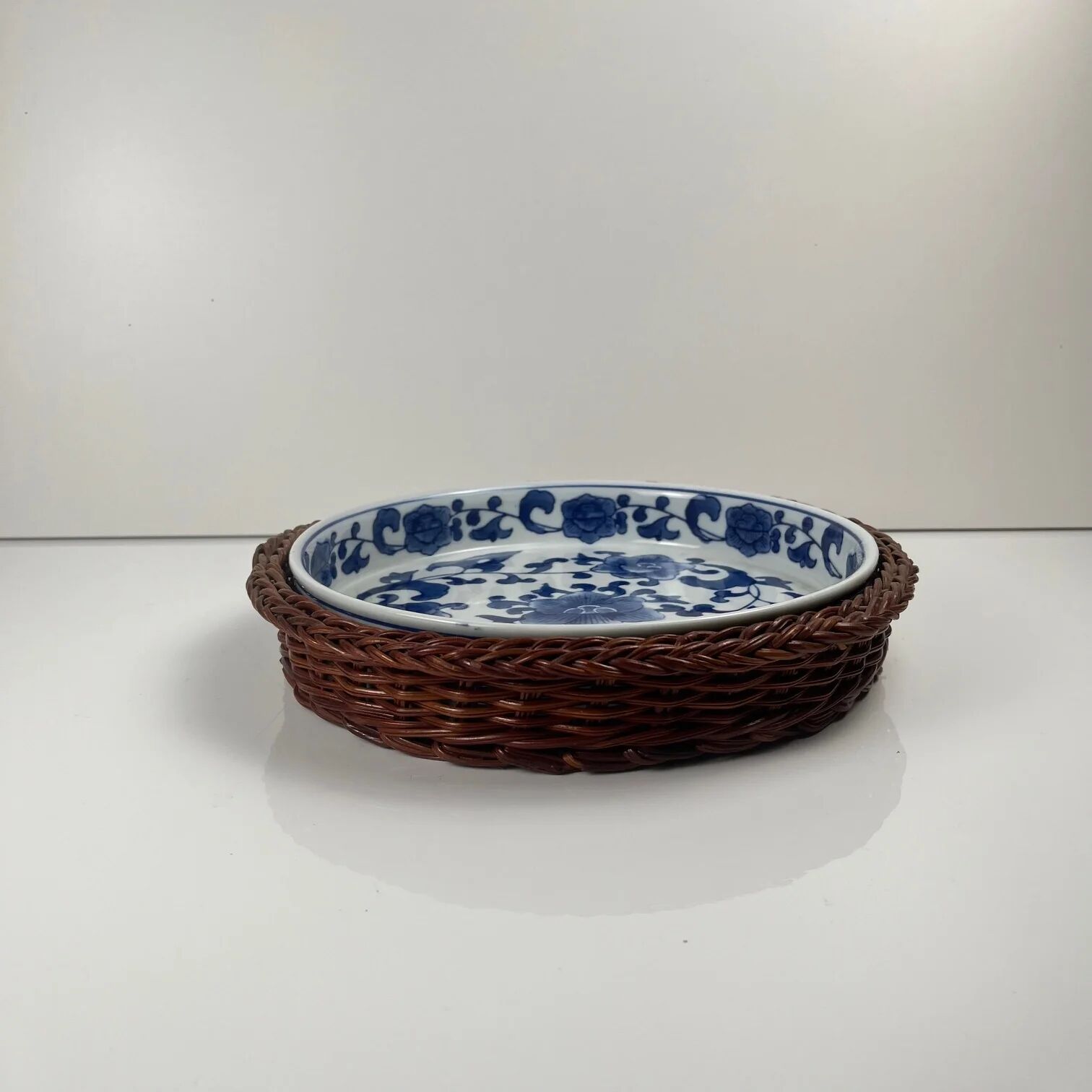 Set of 6 ceramic presentation plates in white and blue, floral pattern with woven wicker frame, 1970s/80s.