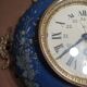 Wall clock in glazed earthenware decoration and brass chain empire style