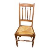 Solid wood chair with a straw seat and carved bar backrest.