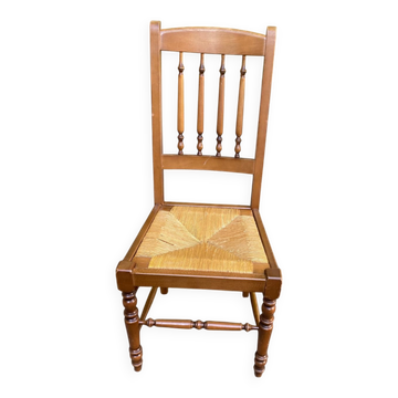 Solid wood chair with a straw seat and carved bar backrest.