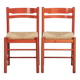 Set of two red vintage wooden chairs from the 1970s with woven rattan seats