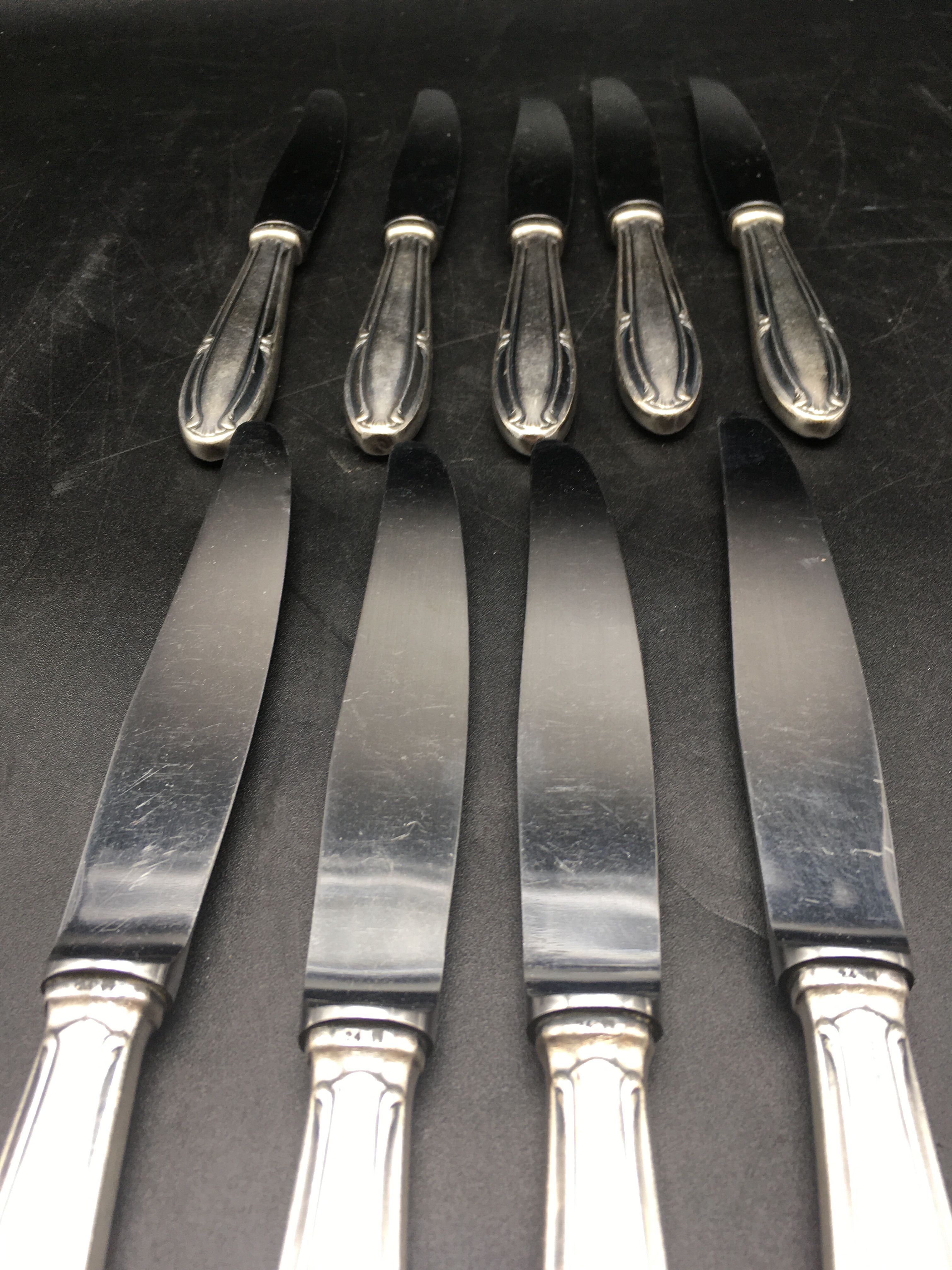 9 table knives in silver metal.