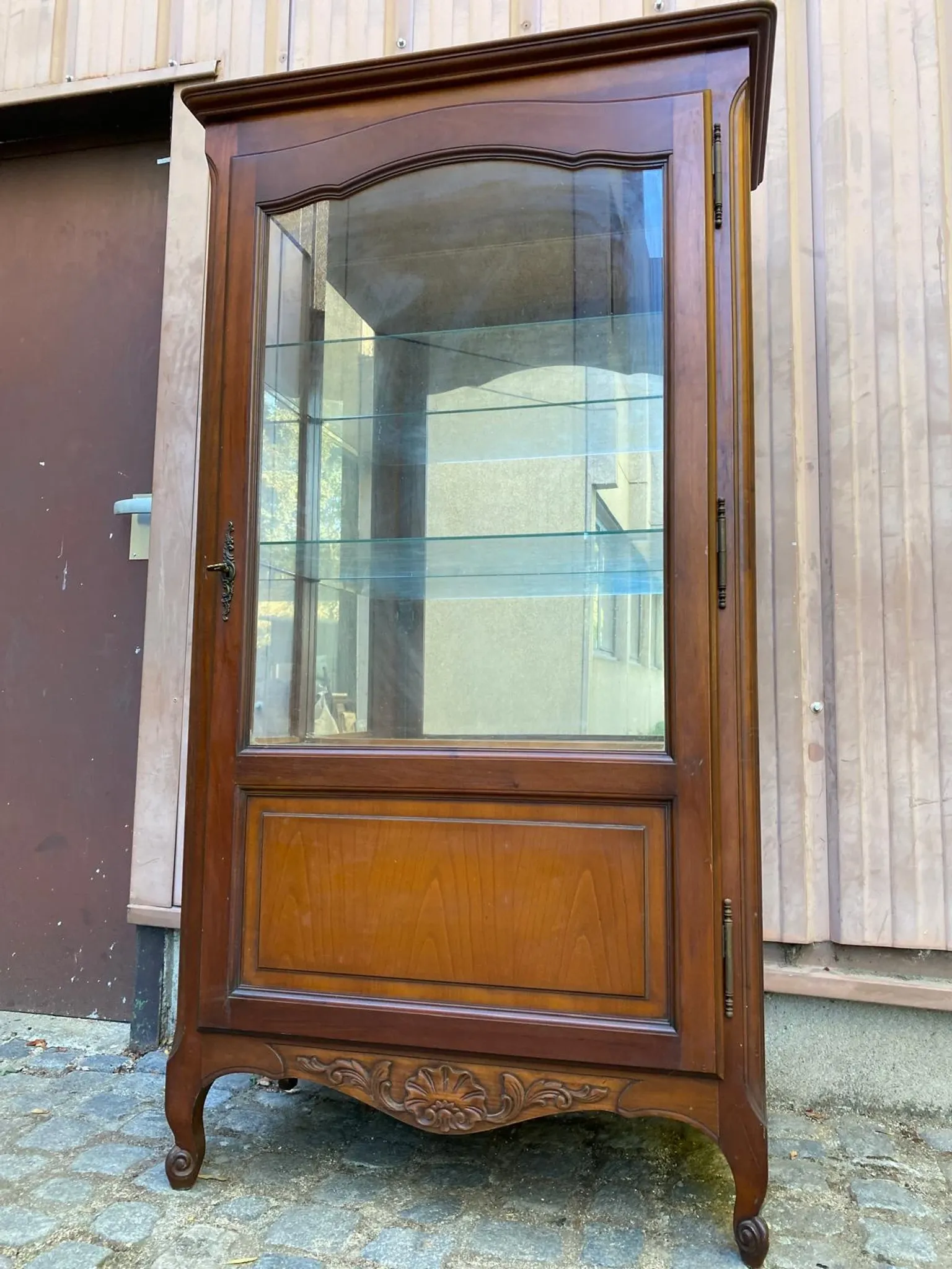 Louis XV style display cabinet in cherry wood with a mirrored back and glass shelves.