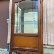 Louis XV style display cabinet in cherry wood with a mirrored back and glass shelves.