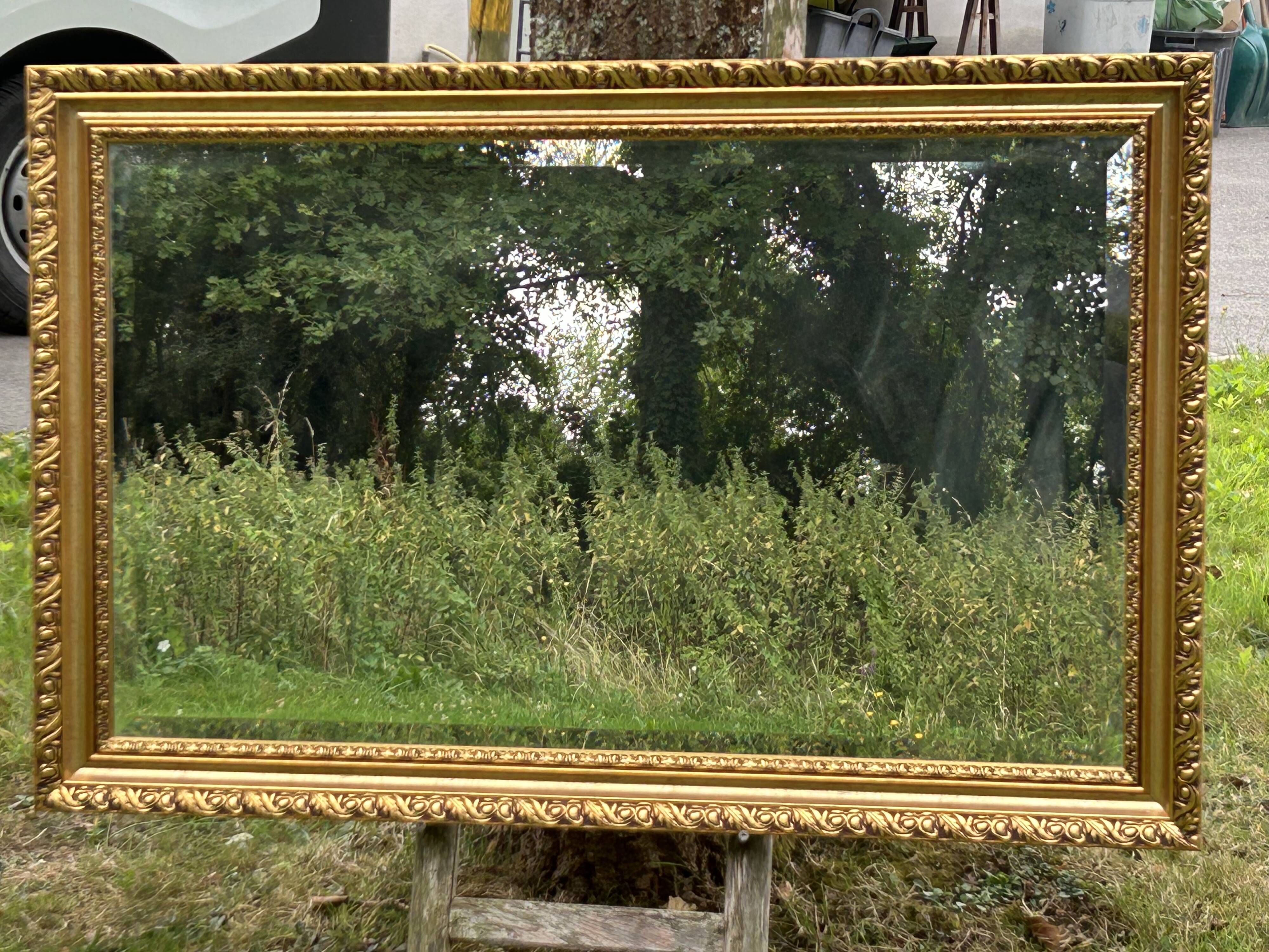 Large beveled mirror in wood and gilded stucco